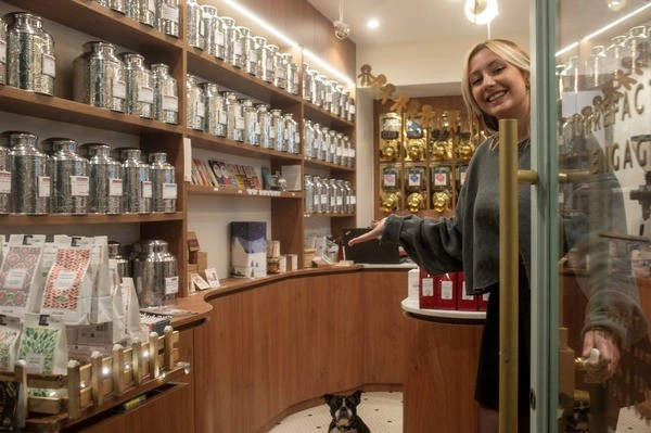 La gérante de la boutique MisterBean de Versailles ouvre la porte pour accueillir les clients à la recherche de bon café en grain