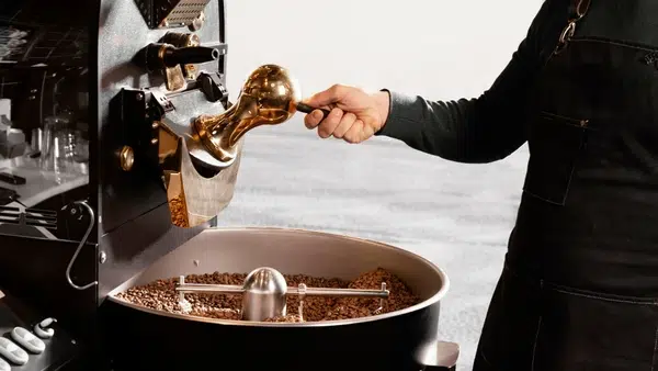 Un artisan torréfie des grains de café.