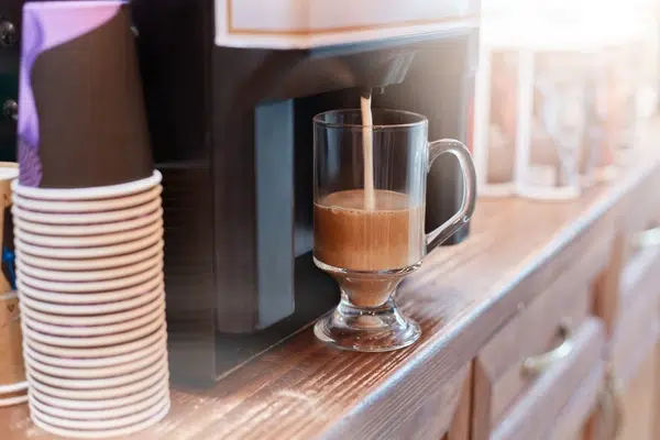 Un distributeur automatique de boissons chaudes est en train de préparer un cappuccino