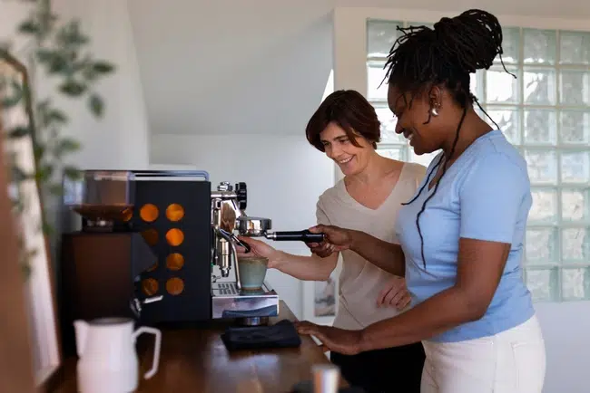 Deux salariées se préparent un café avec une machine à café professionnelle à percolateur