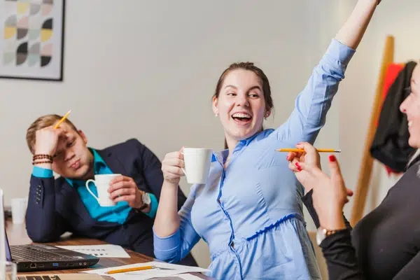 Trois collaborateurs réussissent à trouver une solution au travail autour d'un café.