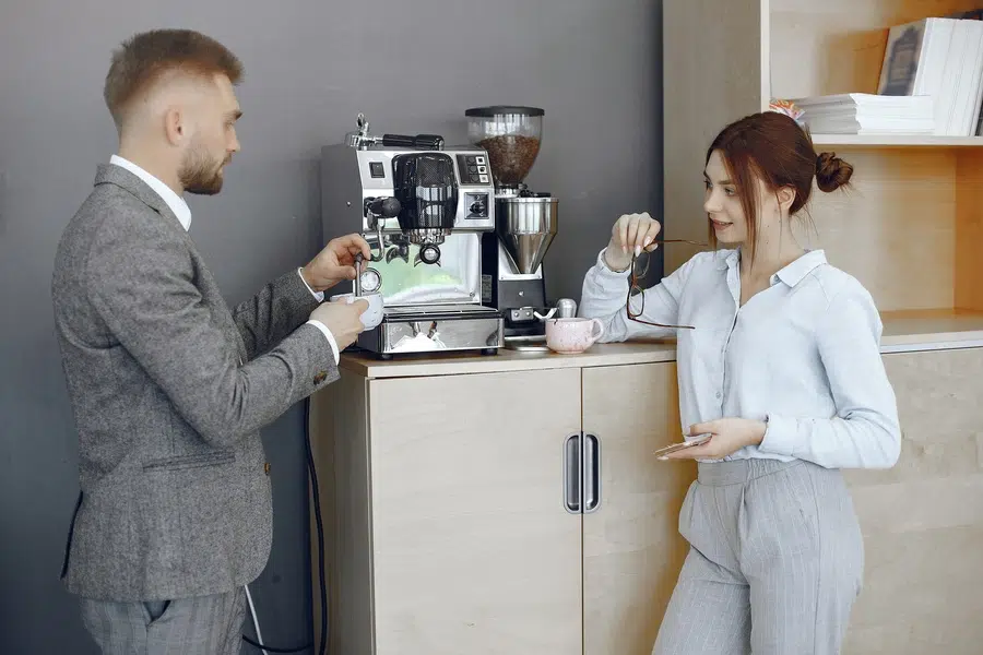 Des salariés d'une entreprise boivent le café autour d'une machine automatique