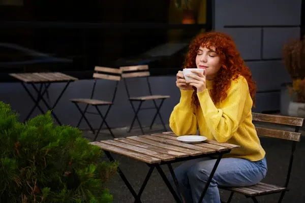 personne assise buvant un café avec joie